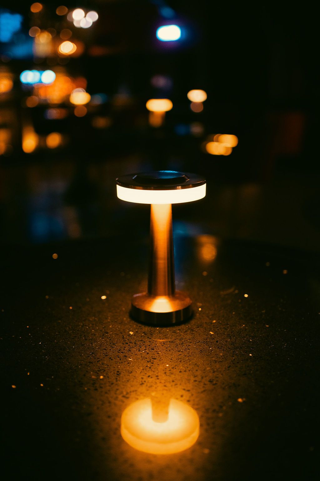 A single brass table lamp glowing in a dark room